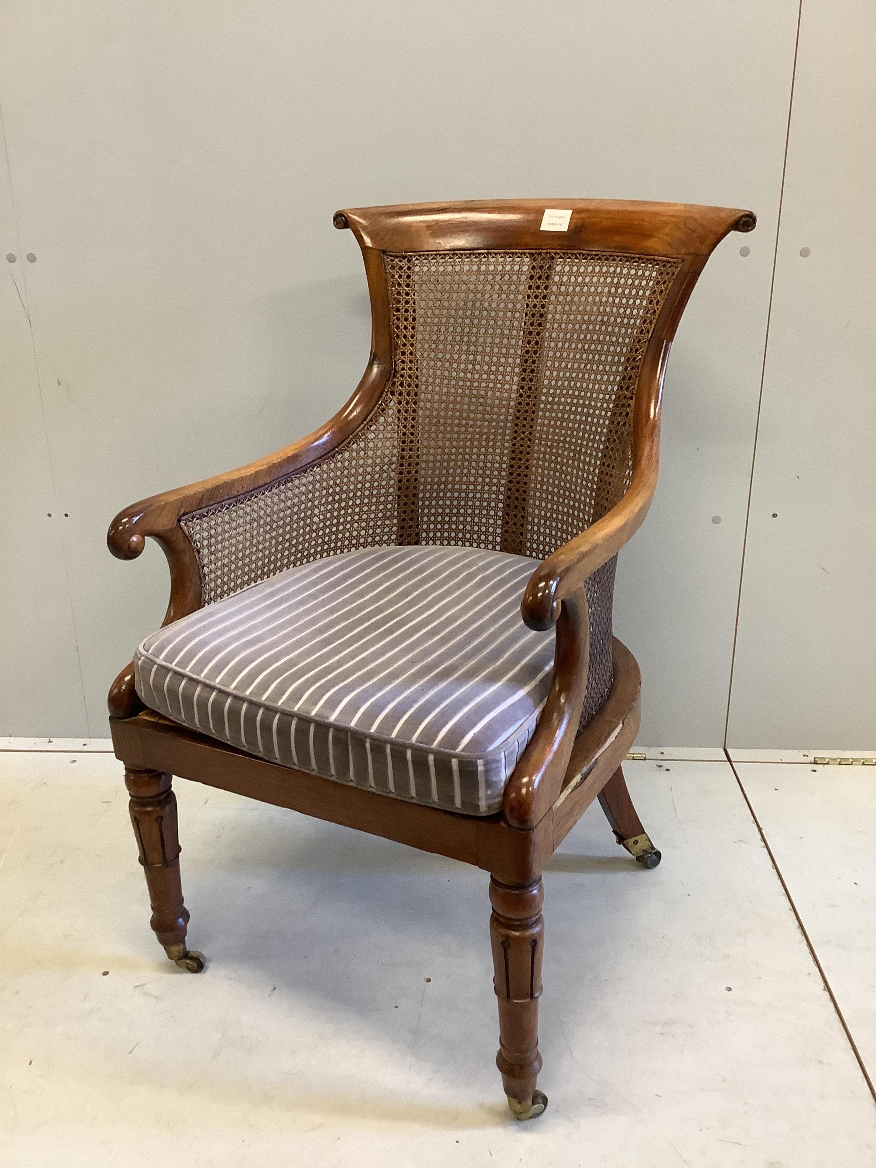 A William IV rosewood bergere library armchair, width 57cm, depth 74cm, height 98cm. Condition - fair, frame faded and has seen much restoration work with repairs to several areas, the cane is good.